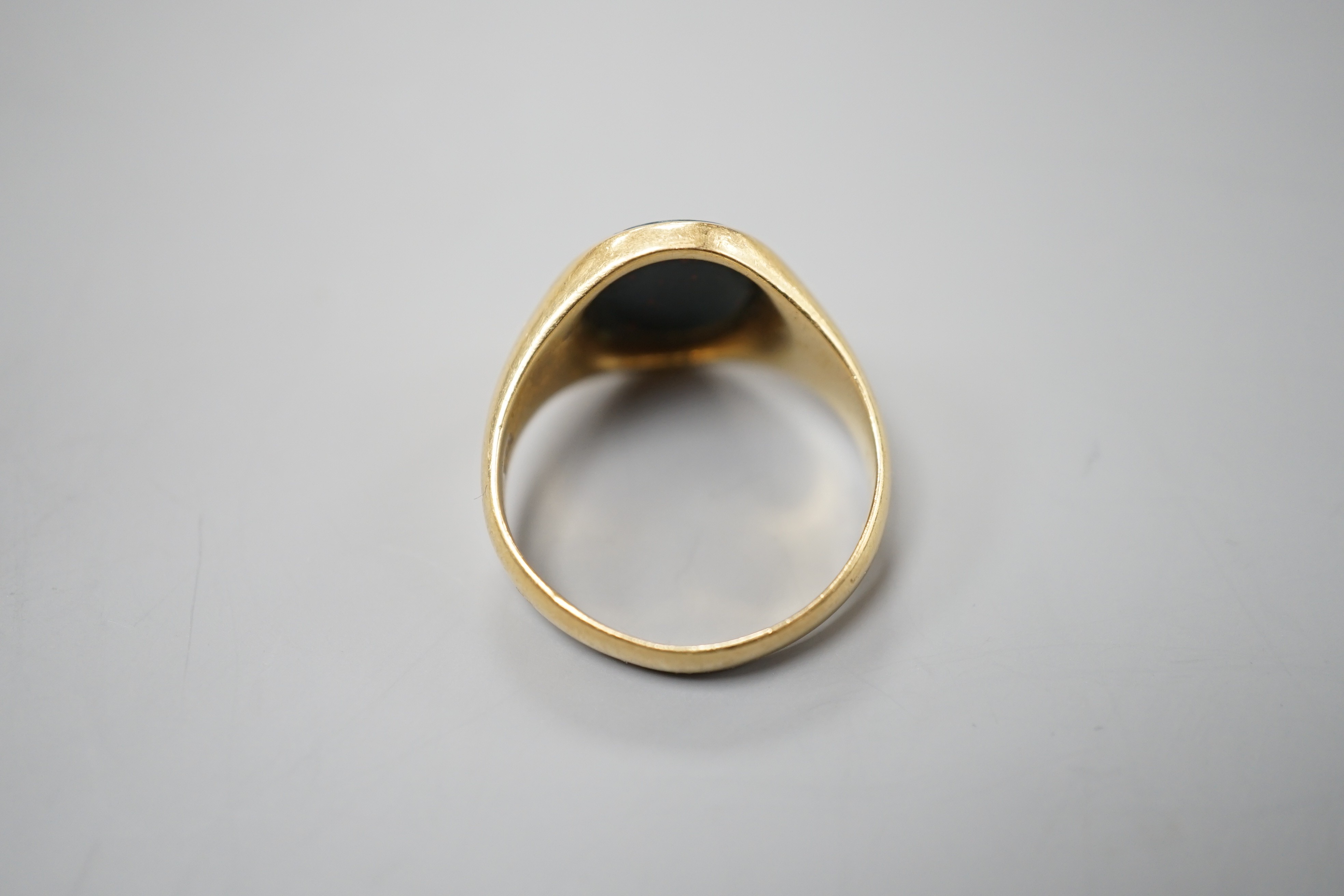 A yellow metal (stamped 18) and bloodstone set oval ring, size S/T, gross 7.9 grams.